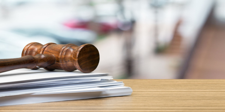 gavel on stack of papers, on wood desk