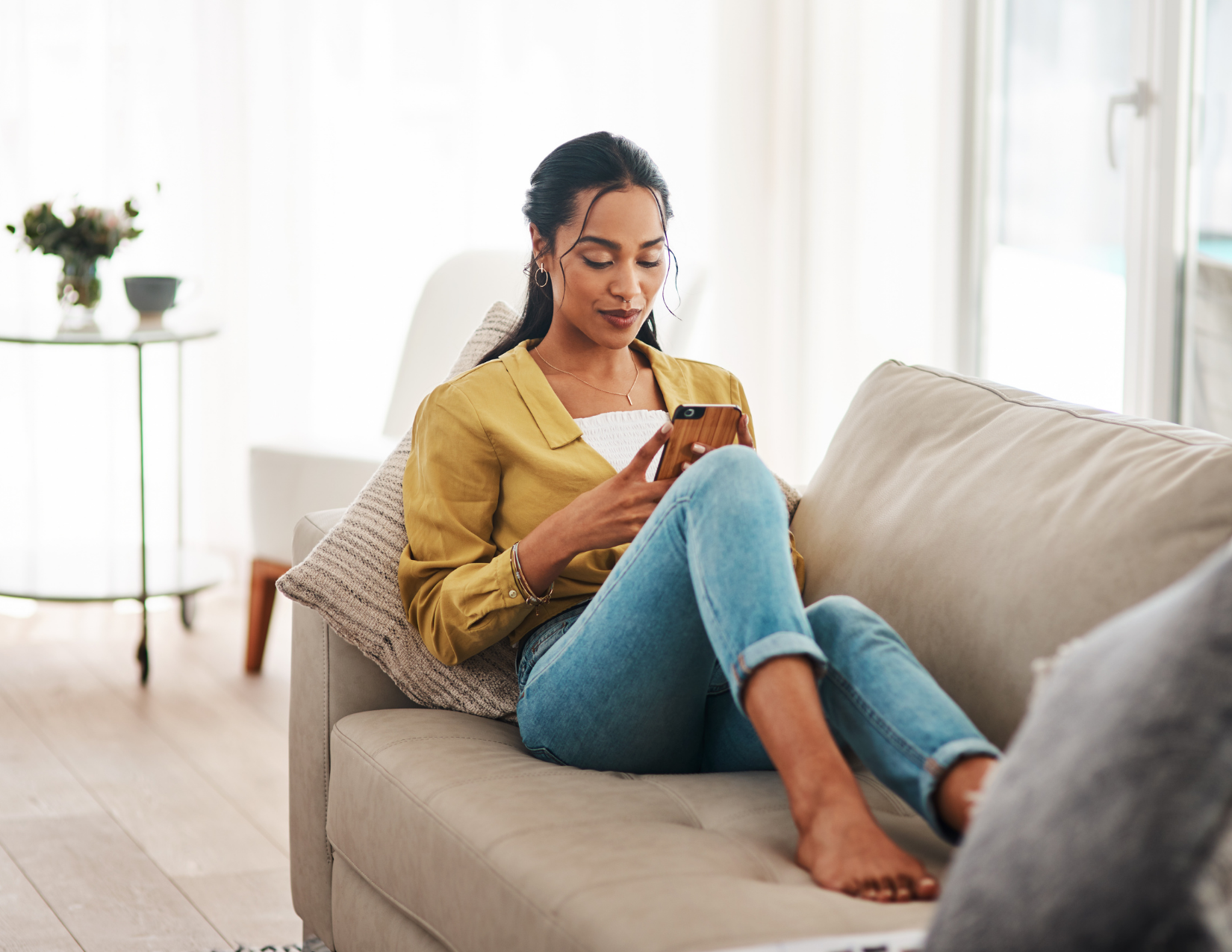 woman on the couch looking at her phone